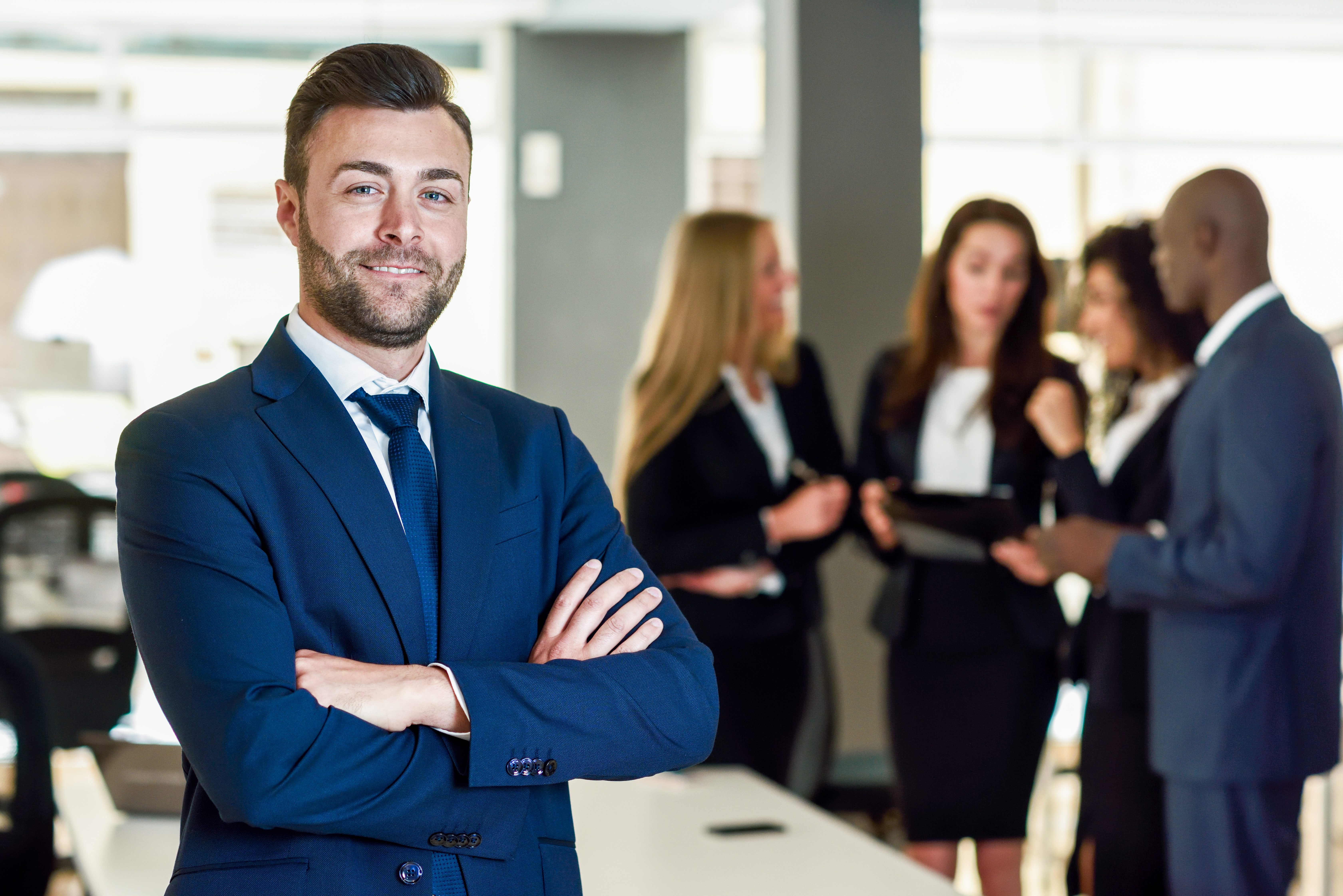 Businessman leader in modern office with businesspeople working.