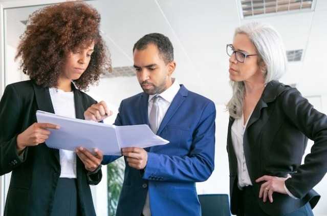 Confident office employers checking documents together.